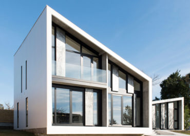 Plano general de una casa de diseño modular con cristaleras y acabados marmolados combinados con metal negro y paredes exteriores blancas