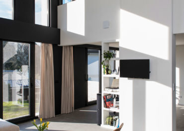 Fotografía interior de una casa de diseño con decoración minimalista y sillas de diseño acabadas en madera.