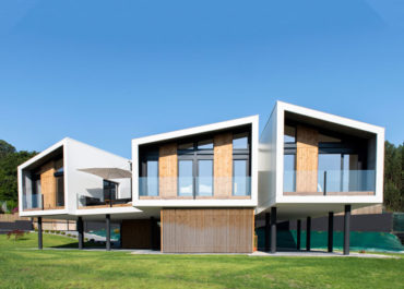 plano general de la casa modular terminada y acabada cielo azul día soleado, césped verde