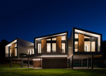 Vista de noche de una casa iluminada modular de diseño