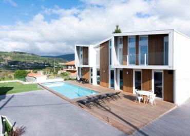 Imagen de una bonita casa construida con el sistema Walluminium por Proyectopia con piscina