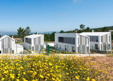 Vista de varias casas modulares de diseño en un campo de flores